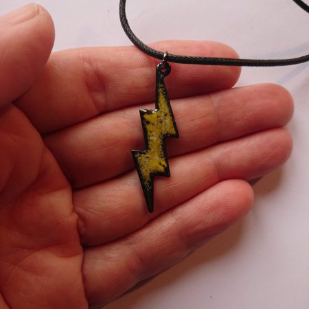 Yellow with dots lightning enamelled copper necklace with waxed cord being held