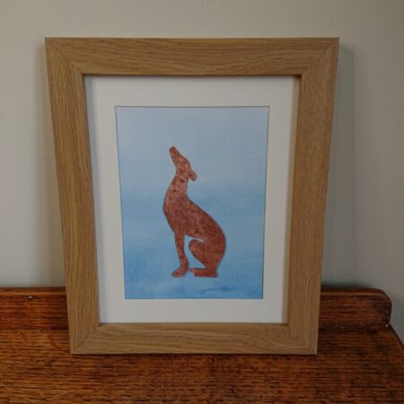 Copper greyhound wall hanging or wall art with a sitting greyhound or whippet made from textured copper, framed with a watercolour blue background