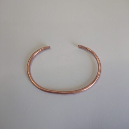 Copper wire cuff style bangle or bracelet in shiny copper with light hammer marks.