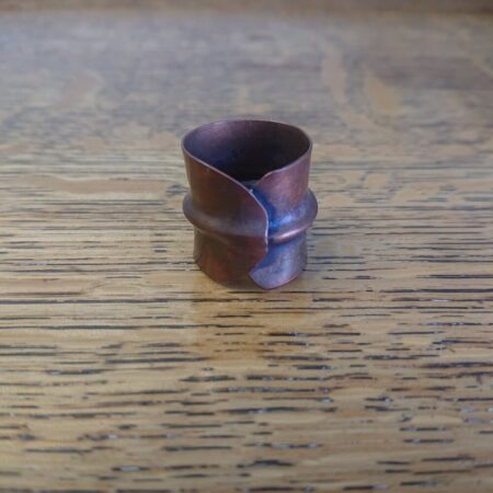 Copper ring with an overlapping style and centre ridge made by fold forming. The copper has an aged copper colour patina.