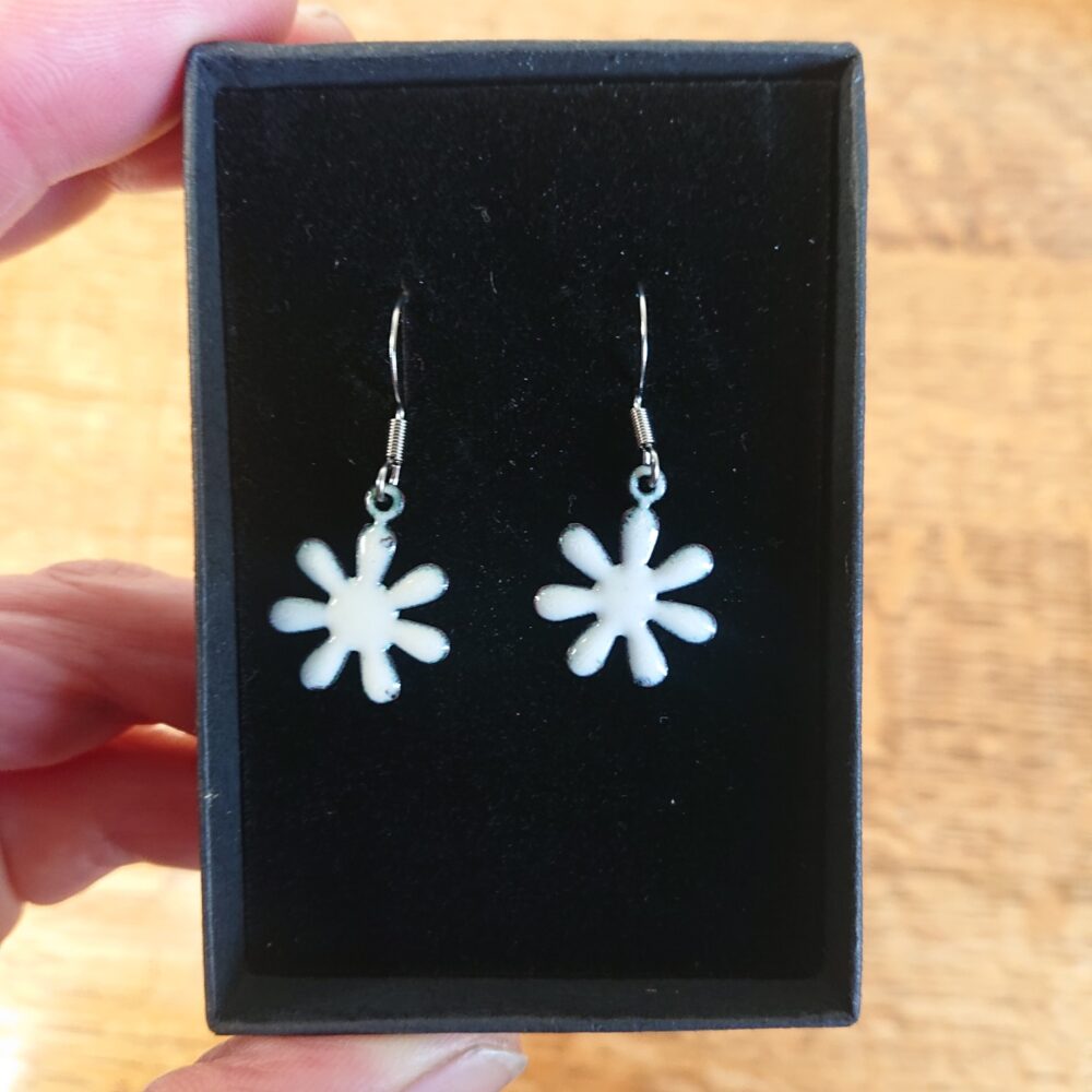 Creamy white enamelled copper earrings with ear hooks and black presentation box. The earrings are flower shaped