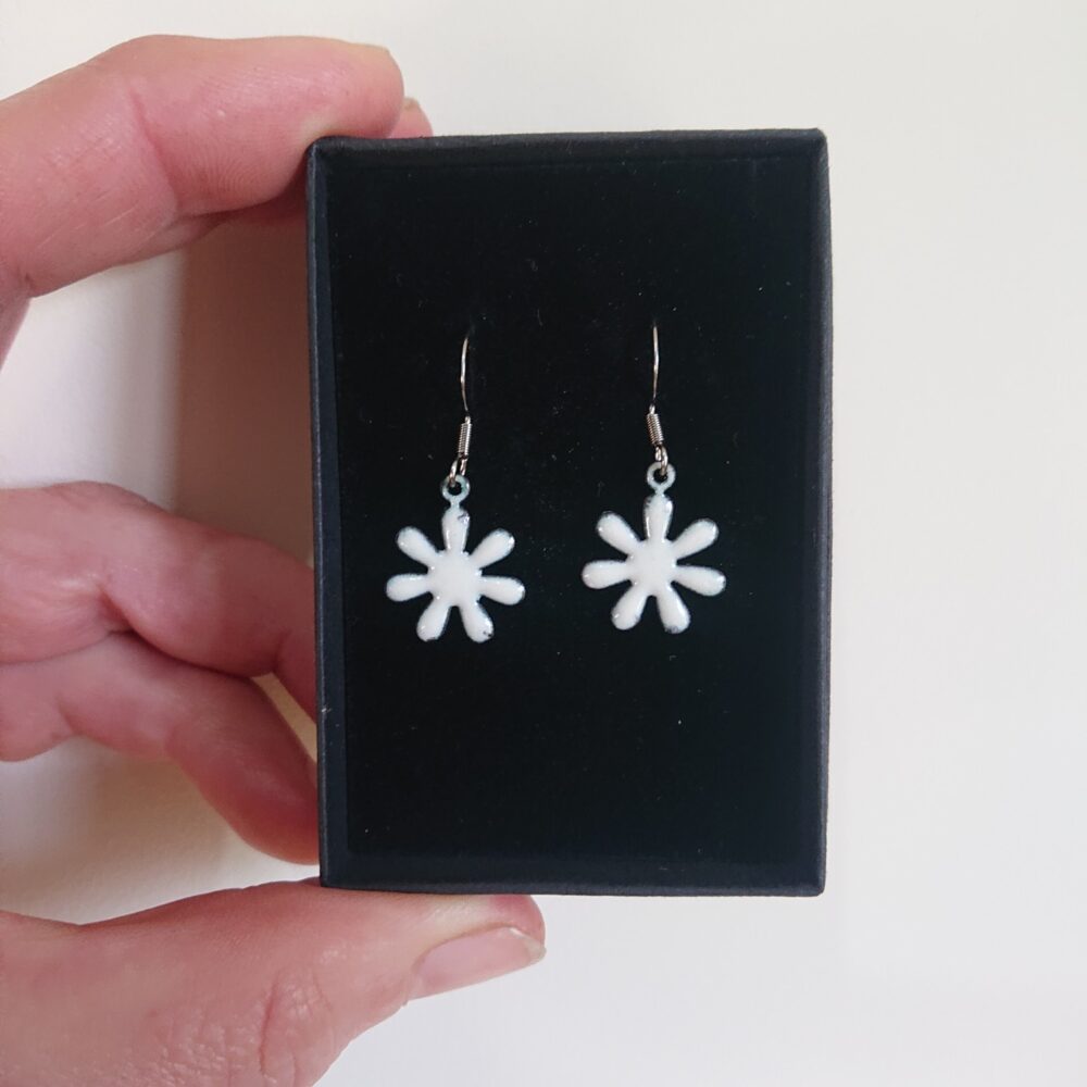 Creamy white enamelled copper earrings with ear hooks and black presentation box. The earrings are flower shaped