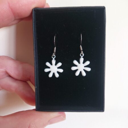 Creamy white enamelled copper earrings with ear hooks and black presentation box. The earrings are flower shaped