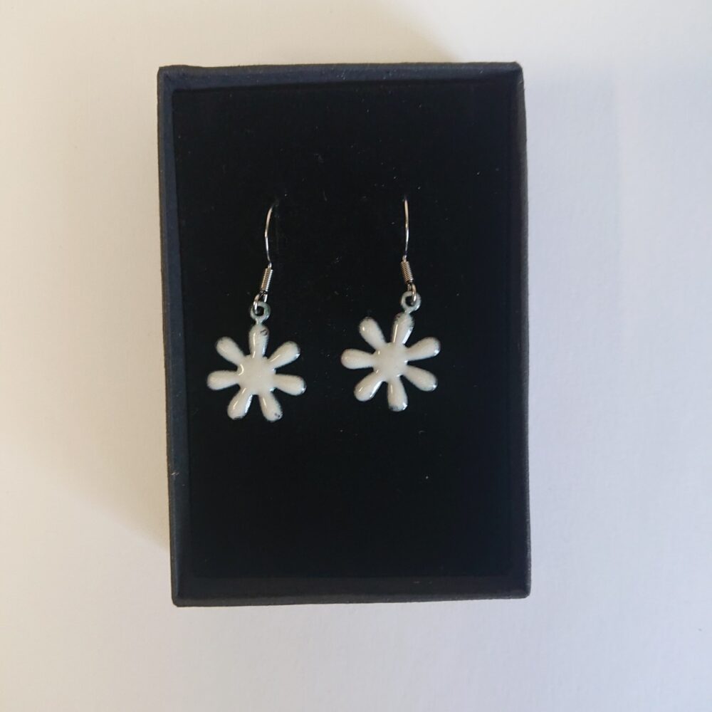 Creamy white enamelled copper earrings with ear hooks and black presentation box. The earrings are flower shaped